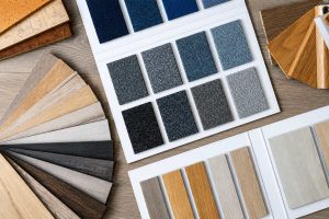 Flooring samples with carpet swatches, wood-look planks, and hardwood colour options for choosing condo flooring materials.