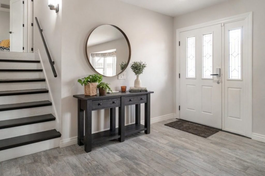 Bright home entryway with stairs and durable grey flooring near the front door.
